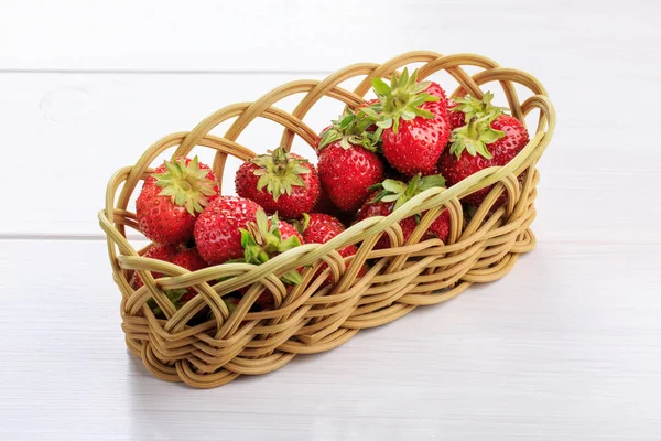 Frische Erdbeeren im Weidenkorb auf einem weißen Tisch — Stockfoto