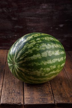 Kahverengi ahşap masadaki tüm yeşil karpuz.