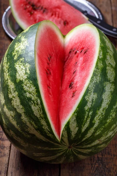 Gesneden rijpe watermeloen op bruin houten tafel. — Stockfoto
