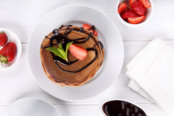 Stapel Schokolade-Pfannkuchen mit Schokoladenbelag und Erdbeere — Stockfoto