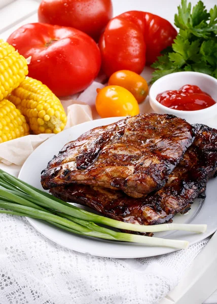 Costelas de porco grelhadas. Carne bbq costelas servidas com molho e legumes frescos — Fotografia de Stock