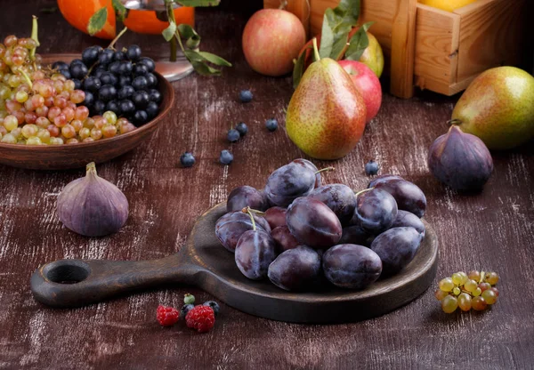 Bodegón de frutas de otoño sobre fondo oscuro. Uvas, melón , — Foto de Stock