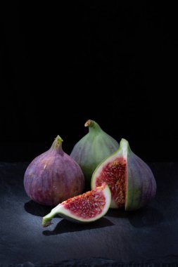 Taze olgun incir ler koyu arka planda yakın çekim. Kopyalama alanı.