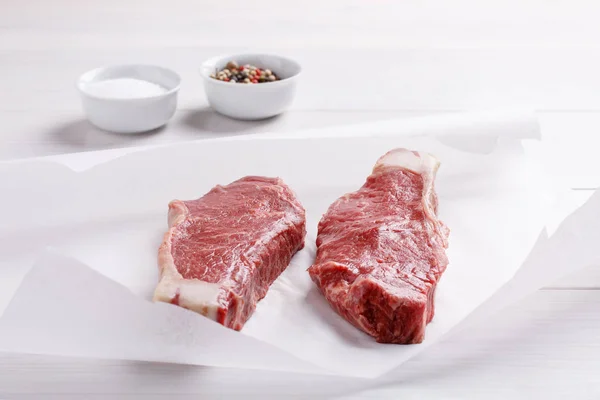 Raw beef striploin steak. Two strip loin steaks on white table. — Stock Photo, Image