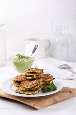 Kabaktan sebzeli börek. Yeşil pesto soslu sebzeli pirzola. Vejetaryen krepleri beyaz masada. Sağlıklı gıda konsepti.