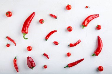 Beyaz arka planda kırmızı biber ve domates deseni. Üst manzara, düz yatak, yakın çekim. Ramiro ve acı biber, vişneli domates. Yiyecek konsepti.