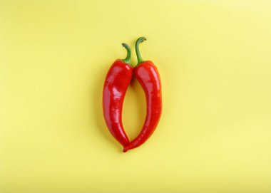 Sarı arka planda kırmızı biber. Üst görünüm, kopyalama alanı, düz döşeme, yakın çekim. Yiyecek konsepti.