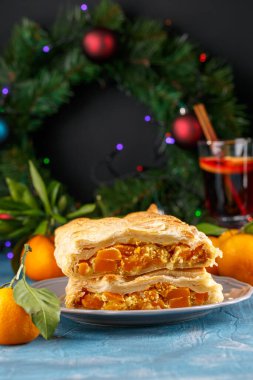 Mavi bir masada ev yapımı lezzetli balkabağı turtası. Noel ve Yeni Yıl dekorasyonu. Kış tatili konsepti.