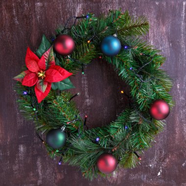 Süslü Noel çelengi ve ahşap arka planda neşeli çelenkler. Yeni Yıl Dekorasyonu.