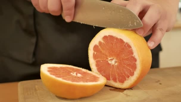 Männerhände schneiden frische Orange — Stockvideo