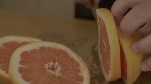 新鮮なオレンジを切る手をマンします。 — ストック動画