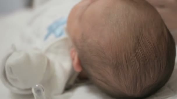 Мать расчесывает новорожденного ребенка — стоковое видео