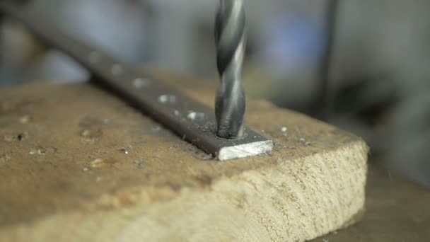 Een man is gespecialiseerd in het boren van gaten in een boormachine in een metalen werkstuk. — Stockvideo