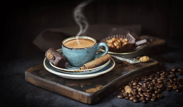 Taza de café sobre fondo rústico. Espresso con palitos de canela  , — Foto de Stock