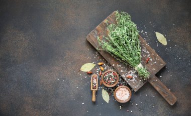 Tahtaya biber ve pembe tuz serpiştirilmiş taze kekik. Eski tarz üst manzara.