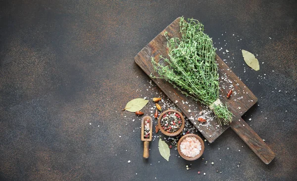 Tahtaya biber ve pembe tuz serpiştirilmiş taze kekik. Eski tarz üst manzara.