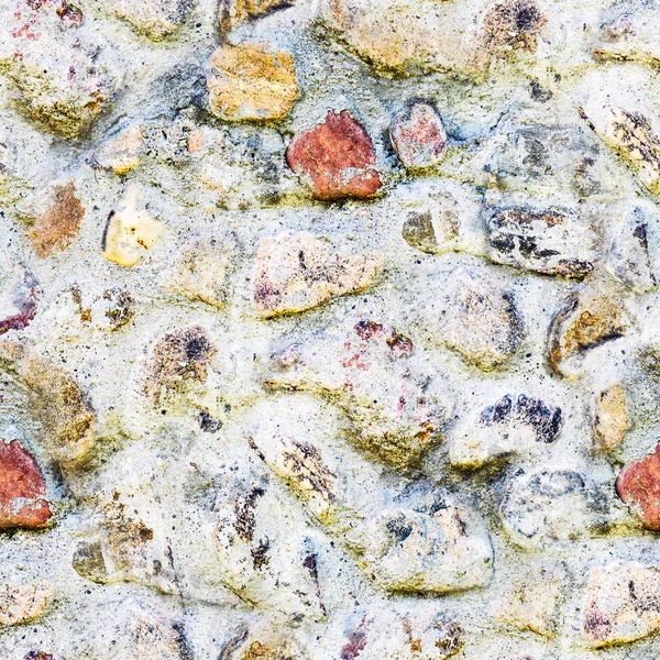 Seamless background of old stone wall texture photo. Colorful old stone wall.