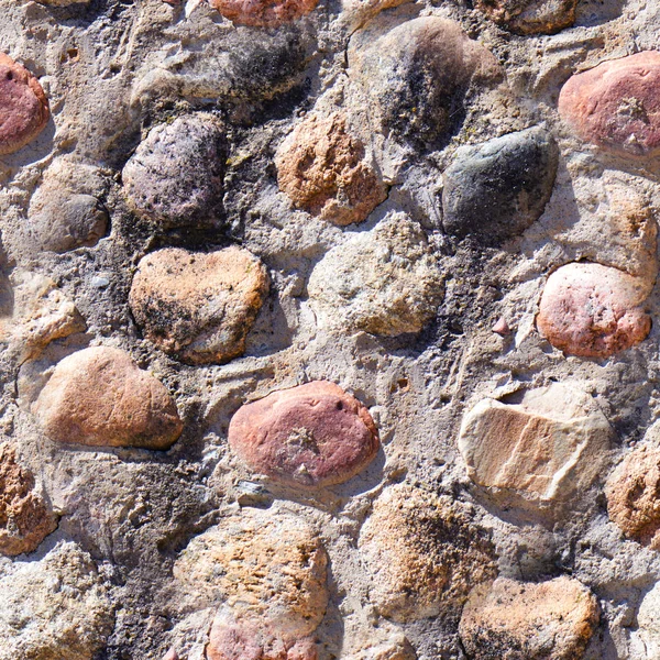 Seamless background of old stone wall texture photo. Colorful old stone wall.