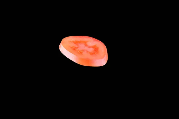 Siyah arka plan üzerine izole kırmızı domates dilimlenir. Havada yüzer düşüncesizlik sebze — Stok fotoğraf