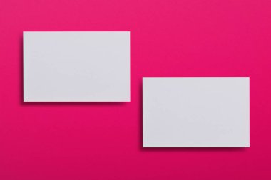 Yukarı iki yatay beyaz kartvizit Pembe dokulu kağıt arka plan, alay et. Mock-up kimlik marka için şablon. Grafik tasarımcıları sunumlar ve Portföyleri için