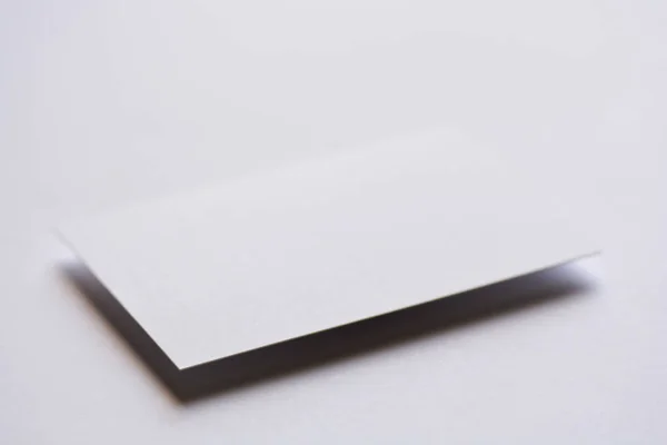 Foto av tomma vita visitkort på vitt. Mock-up för branding identitet. För grafiska formgivare presentationer och portföljer — Stockfoto