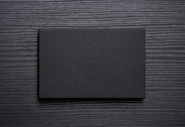 Mockup της κενό σαγρέ μαύρο επαγγελματικής κάρτας σε σκούρο φόντο ξύλου — Φωτογραφία Αρχείου
