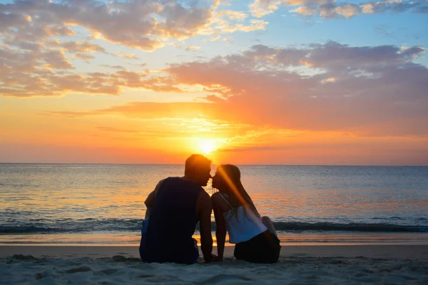 ビーチで夕日を見てカップル — ストック写真