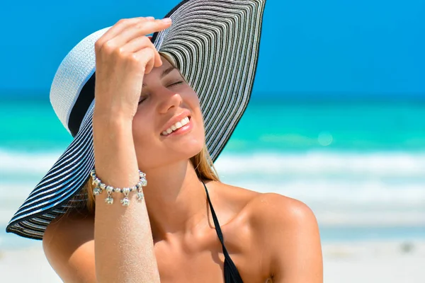 Dopasuj uśmiechniętą dziewczynę na tropikalnej plaży z kapeluszem. Seksowna kobieta z kapeluszem na raju tropikalnej plaży. Piękne dopasowanie ciało dziewczyna na wakacje podróży. Przycinanie wstęgi dla przestrzeni kopiowania. — Zdjęcie stockowe