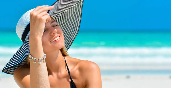 Dopasuj uśmiechniętą dziewczynę na tropikalnej plaży z kapeluszem. Seksowna kobieta z kapeluszem na raju tropikalnej plaży. Piękne dopasowanie ciało dziewczyna na wakacje podróży. Przycinanie wstęgi dla przestrzeni kopiowania. — Zdjęcie stockowe