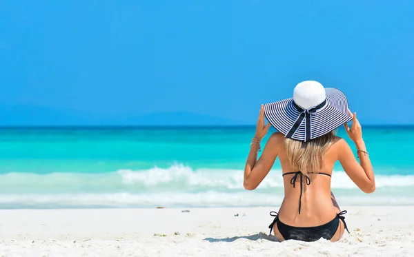 Bikini seksi kadın tropikal tatil keyfini çıkarın. Şapkalı kız yaz tatilinde rahatlatıcı. Bikini içinde mükemmel seksi spor vücut ile kız denize yakın beyaz kum tropikal plajda rahatlatıcı Istirahat.