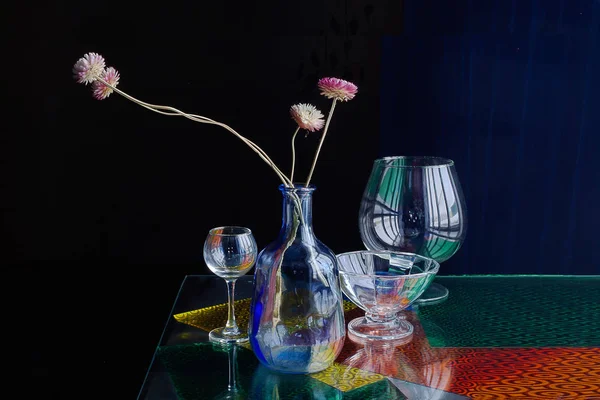 Glass vases and bottles interestingly lie on the windowsill isolated on a dark background.