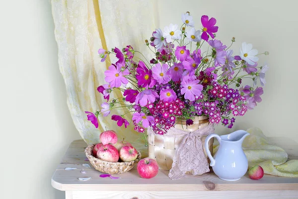 Bir vazo içinde Pembe buket ve hafif bir arka plan üzerinde doğal, olgun elma sepeti ile natürmort