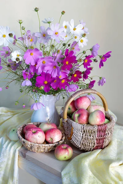 Bir vazo içinde Pembe buket ve hafif bir arka plan üzerinde doğal, olgun elma sepeti ile natürmort