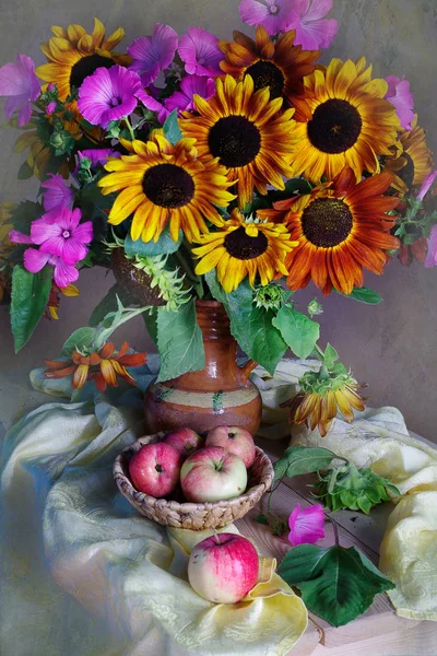 Beautiful bouquet of sunflowers and ripe, natural apples on the table