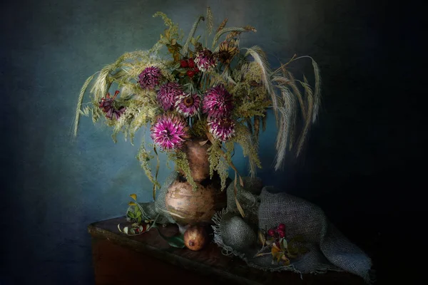 Natürmort mavi bir arka plan üzerinde retro tarzı bir kil vazoda kurutulmuş çiçek