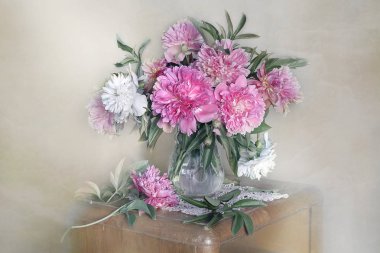 Masadaki vazoda güzel, pembe şakayıklardan oluşan bir buket. Pembe şakayıkların natürmortu.