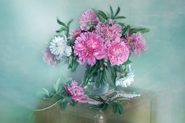 Masadaki vazoda güzel, pembe şakayıklardan oluşan bir buket. Pembe şakayıkların natürmortu.