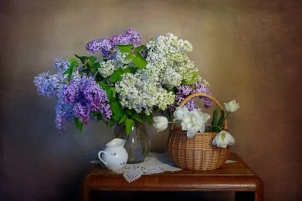 Masanın üzerinde bir vazoda natürmort Eflatun çiçekler.