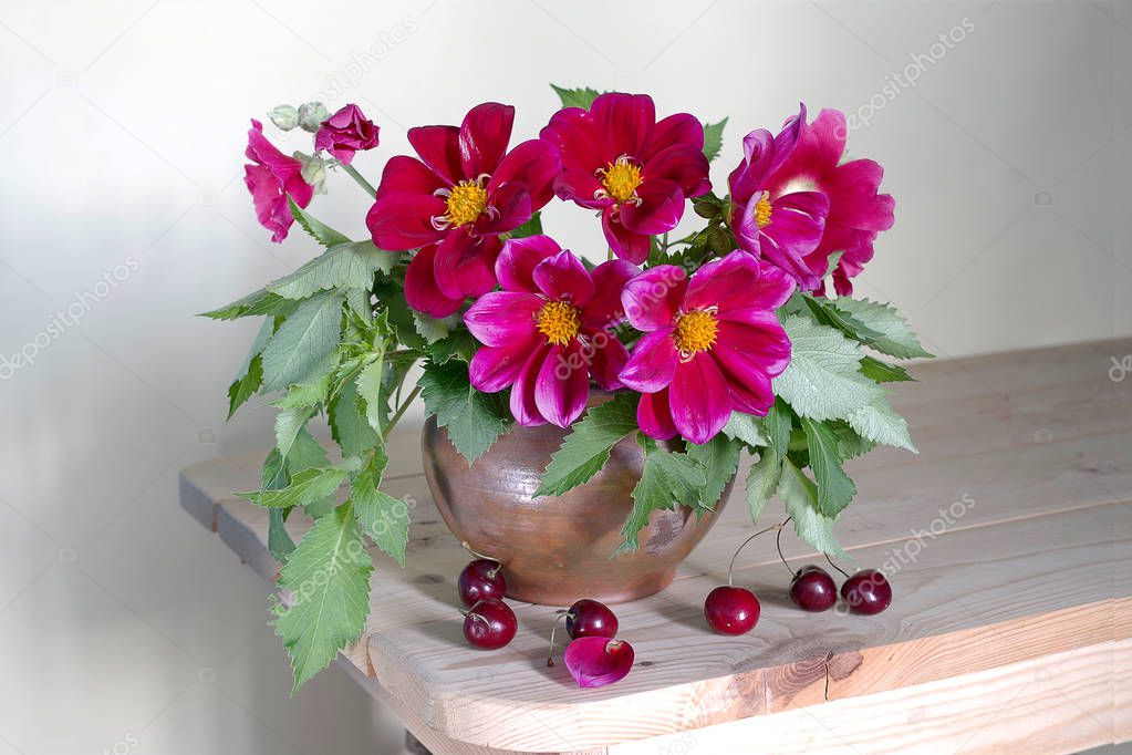 Still life with red dahlias in a vase on a light background