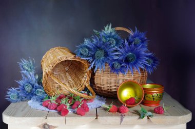 Mavi çiçekler ve kırmızı çilek ile natürmort