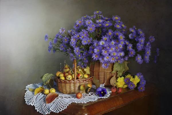 Vazoda bir buket mavi papatyayla hayat, kahverengi arka planda olgun elmalar..