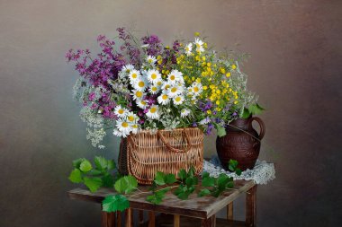 Bir buket papatya ve sepetteki yabani çiçekler..