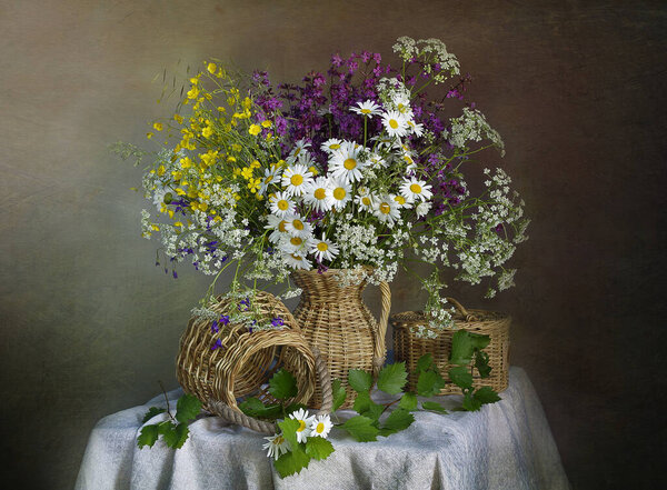 A bouquet of daisies and wildflowers in a vase.