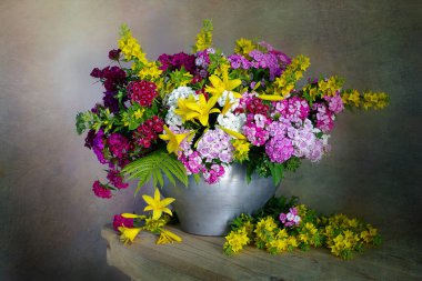 Masadaki vazoda renkli çiçekler.