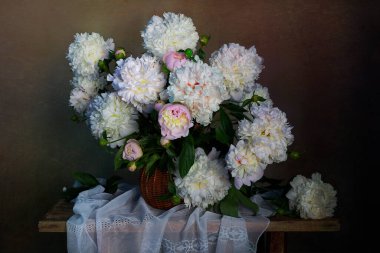 Beyaz, güzel şakayıklarla dolu bir sepetin içinde.