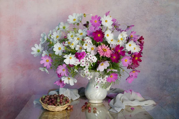 Masadaki vazoda pembe papatyalarla dolu bir hayat.