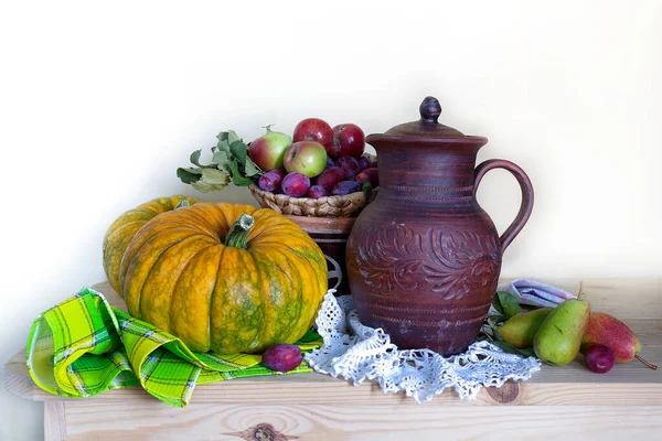 Autumn thanksgiving background, seasonal autumn berries, pumpkins, apples and flowers on a wooden table.Background of the thanksgiving holiday. Still life with the Thanksgiving concept