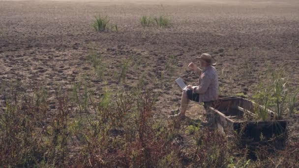 Muži, kteří pracují mimo kancelář s notebookem sedět na břehu jezera — Stock video