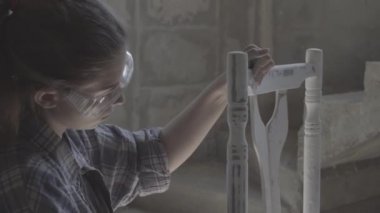 Kız bir doğrama atölyesinde inşaat, mobilya parlatır.