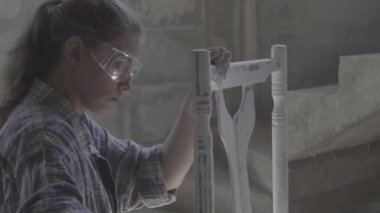 Kız bir doğrama atölyesinde inşaat, mobilya parlatır.